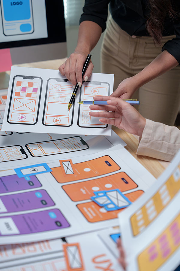 Ui/ux designers are discussing mobile app templates, focusing on user interface and user experience design for a seamless and intuitive mobile application