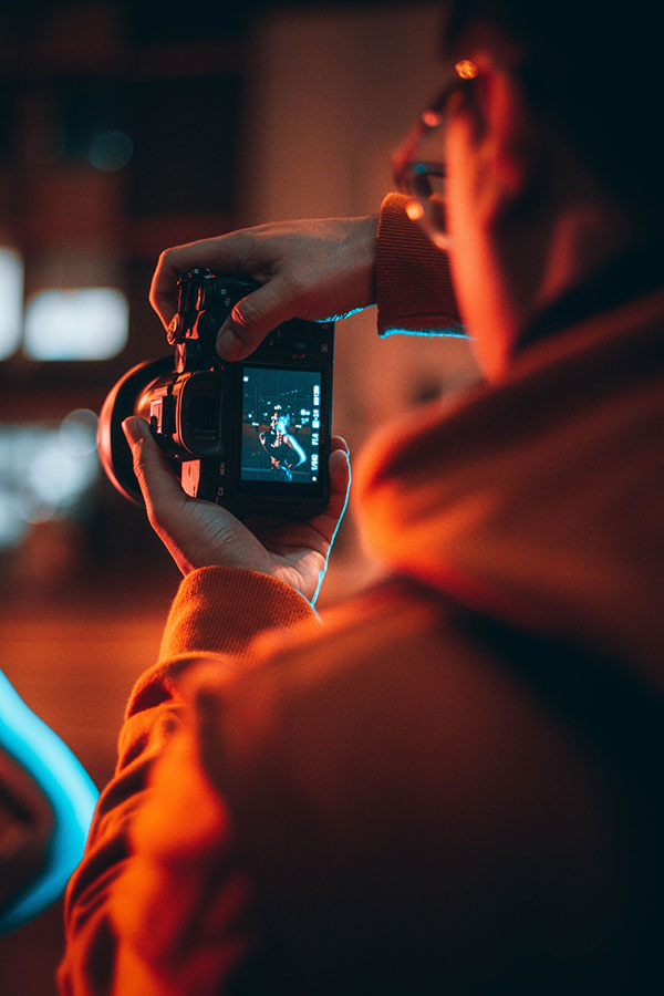 Vertical shot of a professional photographer taking photos at night